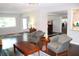 Bright and airy living room with hardwood floors, neutral paint, and a view into the kitchen at 2101 Sunset Point Rd # 2304, Clearwater, FL 33765