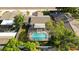 Overhead aerial view of the home highlighting the screened-in pool surrounded by green foliage and adjacent homes at 2233 Curlew Rd, Dunedin, FL 34698