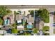 Aerial view of the property with a screened-in pool, surrounded by lush greenery and neighboring homes at 2233 Curlew Rd, Dunedin, FL 34698