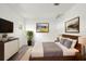 Bedroom featuring a modern bed frame, dresser and plant, with natural light at 2233 Curlew Rd, Dunedin, FL 34698