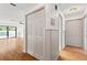Hallway with hardwood floors, closet and trim, leads to pool view through sliding glass doors at 2233 Curlew Rd, Dunedin, FL 34698