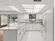 Bright kitchen with white cabinets, granite countertops, and stainless steel appliances overlooking a pool at 2233 Curlew Rd, Dunedin, FL 34698