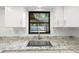 Close-up of a kitchen sink with granite countertops and a window view at 2233 Curlew Rd, Dunedin, FL 34698