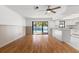 Living room has hardwood floors, open concept kitchen area, and a view of pool outside at 2233 Curlew Rd, Dunedin, FL 34698