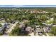 Wide aerial view showcasing a neighborhood with lush trees, single-Gathering homes, and clear blue skies at 2233 Curlew Rd, Dunedin, FL 34698