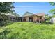 Lush backyard with mature trees, screened-in patio, and partial view of the home's exterior at 2308 Long Green Ct, Valrico, FL 33596