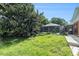 Green grass backyard with a view of the screened in pool and mature landscaping at 2308 Long Green Ct, Valrico, FL 33596