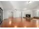 Expansive living room featuring sleek hardwood floors, recessed lighting, and a cozy stone fireplace at 2308 Long Green Ct, Valrico, FL 33596
