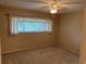 Cozy bedroom featuring a window with blinds and curtains, and neutral carpet at 2410 Franciscan Dr # 18, Clearwater, FL 33763