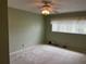 A bedroom featuring neutral walls, carpeted floor, ceiling fan, and window providing natural light at 2410 Franciscan Dr # 18, Clearwater, FL 33763