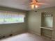 A bedroom featuring neutral walls, carpeted floor, ceiling fan, and window providing natural light at 2410 Franciscan Dr # 18, Clearwater, FL 33763