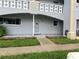 Unit exterior with a covered porch, lawn, and a well-kept garden bed at 2410 Franciscan Dr # 18, Clearwater, FL 33763