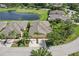 Aerial view of a home with a large backyard, a lake and surrounded by palm trees in a residential neighborhood at 2427 Nottingham Greens Dr, Sun City Center, FL 33573