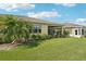 Well-maintained backyard featuring a screened-in lanai, lush green lawn, and vibrant tropical plants for outdoor enjoyment at 2427 Nottingham Greens Dr, Sun City Center, FL 33573