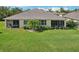 Spacious backyard featuring screened lanais, lush green lawn, and vibrant landscaping perfect for outdoor relaxation at 2427 Nottingham Greens Dr, Sun City Center, FL 33573
