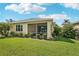 Landscaped backyard featuring a screened-in lanai, lush green lawn, and vibrant tropical plants for outdoor enjoyment at 2427 Nottingham Greens Dr, Sun City Center, FL 33573