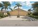 Beige two-car garage home exterior features a driveway and manicured landscaping at 2427 Nottingham Greens Dr, Sun City Center, FL 33573