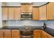 Bright kitchen features wood cabinets, granite countertops and stainless steel appliances at 2427 Nottingham Greens Dr, Sun City Center, FL 33573