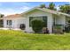 A backyard with a lawn and a patio featuring a table and chairs, and a grill for outdoor dining at 2436 Nuremberg Blvd, Punta Gorda, FL 33983