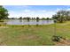 Backyard view showcasing a serene pond, lush green lawn, and a charming birdhouse at 2436 Nuremberg Blvd, Punta Gorda, FL 33983
