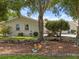 Charming home featuring well-maintained landscaping, mature trees, and a decorative garden gnome accent at 2436 Nuremberg Blvd, Punta Gorda, FL 33983