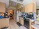 Functional kitchen featuring oak cabinets, appliances, and white tile flooring at 2436 Nuremberg Blvd, Punta Gorda, FL 33983