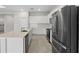 Modern kitchen featuring white cabinets, stainless steel appliances, and a center island with a sink at 2589 Winding Creek Trl, North Port, FL 34289