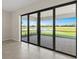 Spacious living area with large sliding glass doors leading to a patio and serene lake views at 2589 Winding Creek Trl, North Port, FL 34289