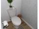 A toilet in a bathroom with gray brick-style tiling at 2617 Cove Cay Dr # 707, Clearwater, FL 33760