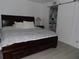 A main bedroom with a dark wood bed frame and an en suite bathroom at 2617 Cove Cay Dr # 707, Clearwater, FL 33760