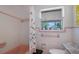 Bathroom with pink tiling, a patterned shower curtain, and a window, creating a vintage charm at 2807 Miriam S St, Gulfport, FL 33711