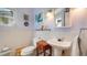 Bathroom with white tile, a pedestal sink, and decorative artwork, enhanced by soft lighting at 2807 Miriam S St, Gulfport, FL 33711