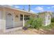 Inviting front porch featuring a cozy seating area and lush, colorful landscaping surrounding the entrance at 2807 Miriam S St, Gulfport, FL 33711