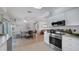 Modern kitchen with white cabinets and stainless steel appliances, adjacent to a dining area with natural light at 2807 Miriam S St, Gulfport, FL 33711