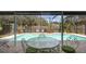 Outdoor seating area with a screened-in pool, surrounded by lush greenery and a privacy fence at 2807 Miriam S St, Gulfport, FL 33711