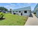 Scenic exterior view of the house surrounded by green grass, plants and a tidy concrete walkway at 302 Andover Pl # G156, Sun City Center, FL 33573