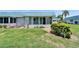 A well-maintained lawn surrounds this single-story home with a blue tiled roof at 302 Andover Pl # G156, Sun City Center, FL 33573