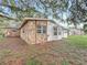 View of back exterior with stone accent, bay window, and partial fence at 307 Fern Cliff Ave, Temple Terrace, FL 33617