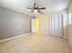 Bright bedroom features tile flooring, a ceiling fan, and access to a connected space at 307 Fern Cliff Ave, Temple Terrace, FL 33617