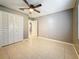 This spacious bedroom features tile flooring, a ceiling fan, and a large closet at 307 Fern Cliff Ave, Temple Terrace, FL 33617