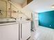 Bright laundry room featuring a washer and dryer with open shelving at 307 Fern Cliff Ave, Temple Terrace, FL 33617
