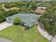 Aerial view of a well-maintained property featuring lush greenery, a private pool, and a brick driveway at 316 Cedar Ln, Largo, FL 33770