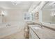 Spacious bathroom featuring a tub, double sinks, and ample counter space with natural light at 316 Cedar Ln, Largo, FL 33770