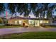 Charming single-story home featuring a brick driveway, manicured lawn, and inviting double doors at 316 Cedar Ln, Largo, FL 33770