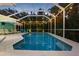 A serene screened-in pool with lounge seating, and ambient string lighting, perfect for relaxation at 316 Cedar Ln, Largo, FL 33770