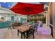 Outdoor patio with dining set under umbrellas, swan pool float and view of the screened-in pool at 316 Cedar Ln, Largo, FL 33770