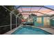 Outdoor pool area under screen enclosure featuring string lights, umbrellas, swan float, and dining area at 316 Cedar Ln, Largo, FL 33770
