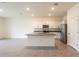 Open kitchen features stainless steel appliances, granite counters, an island, tile floors, and access to living room at 33063 Tulip Petal Ln, Wesley Chapel, FL 33545