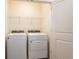 Functional laundry area with modern washer, dryer and wire shelving for storage at 33063 Tulip Petal Ln, Wesley Chapel, FL 33545