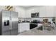 This modern kitchen boasts stainless steel appliances, white cabinets, and dark countertops for a sleek, clean design at 35950 Sunflower Hill Dr, Zephyrhills, FL 33541
